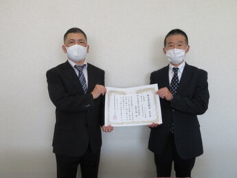 賞状を持つ工場長の画像